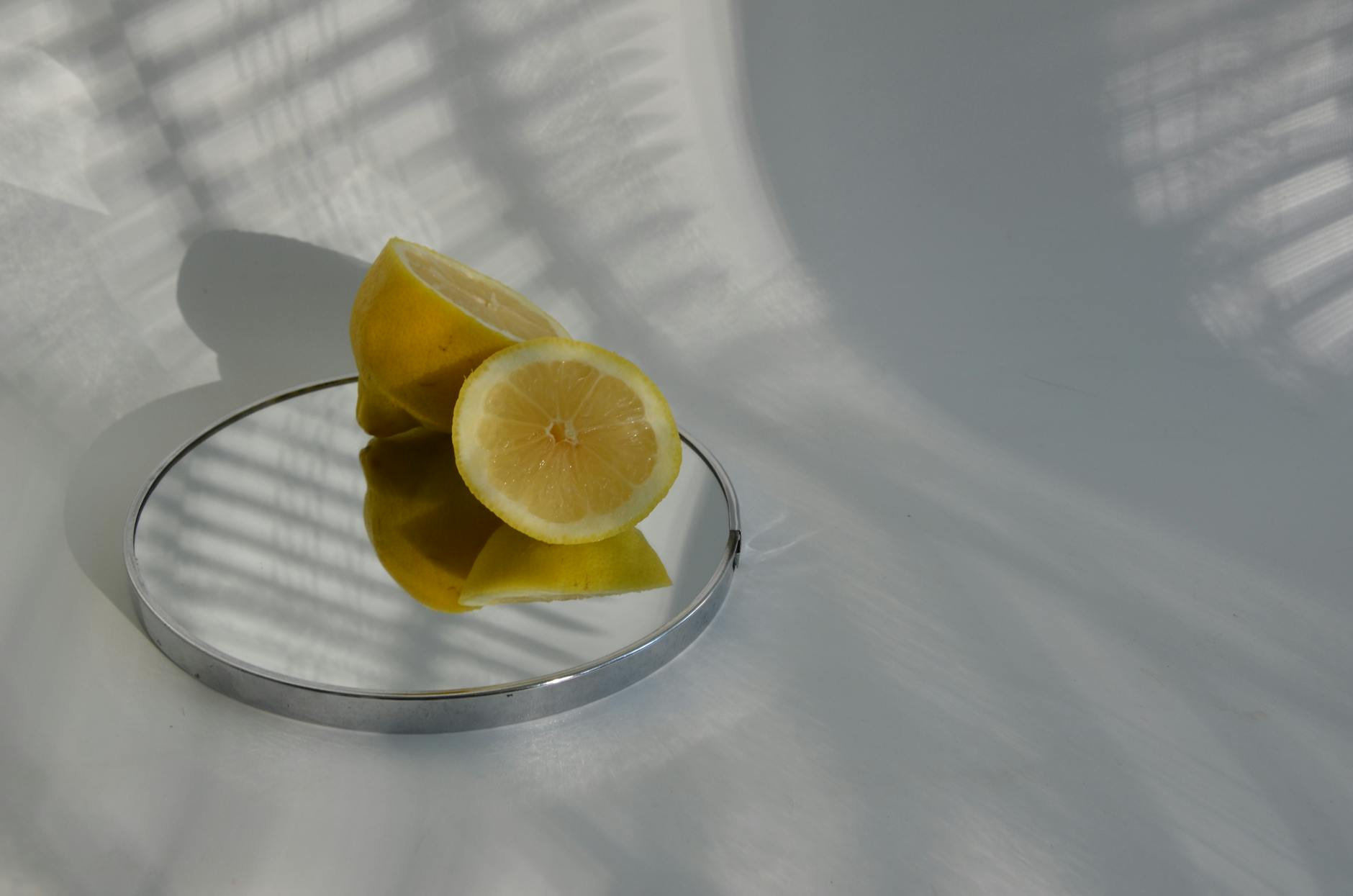 Hand holding a fresh lemon on pink background