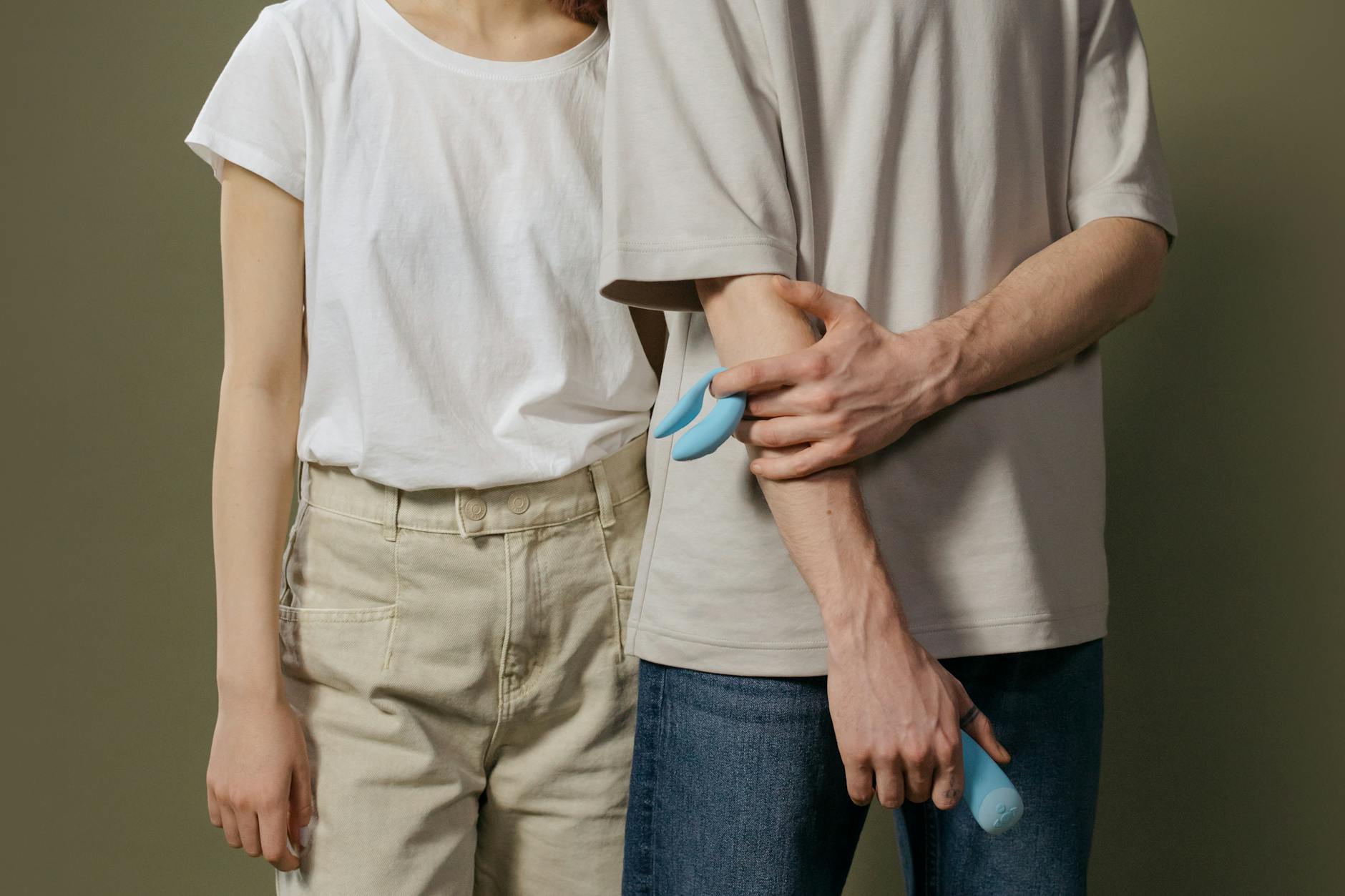 Close-up of a hand holding an orange vibrator, showcasing modern intimacy and sensuality